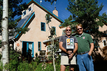 David Ruskay, left, holds his Wildfire Partners yard sign during a visit from Wildfire Partners Mitigation Specialist Andrew Notbohm on July 21, 2016. David, whose home was certified by Wildfire Partners in 2016, credits the wildfire mitigation work he did with helping to save his home during the Cold Springs Fire.