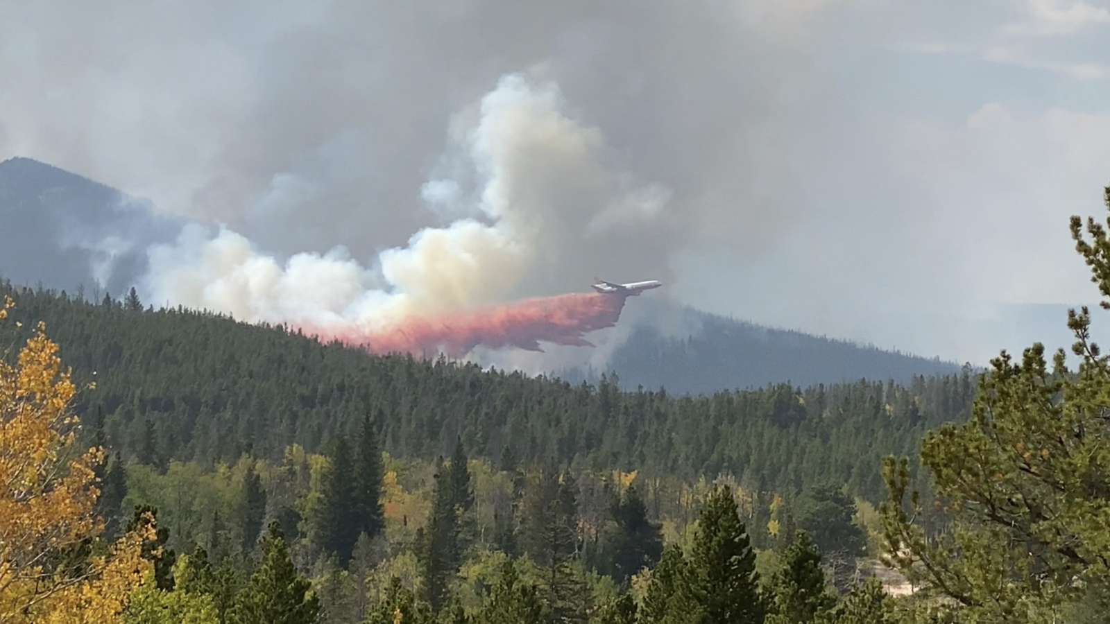Tanker dropping fire retardant over Cameron Peak Fire