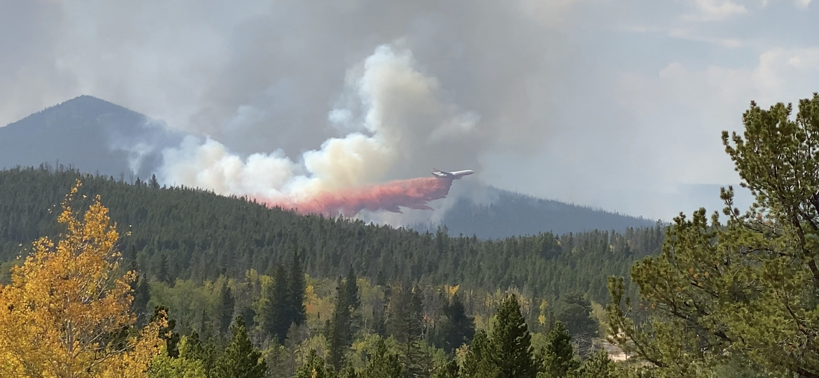 Tanker dropping fire retardant over Cameron Peak Fire