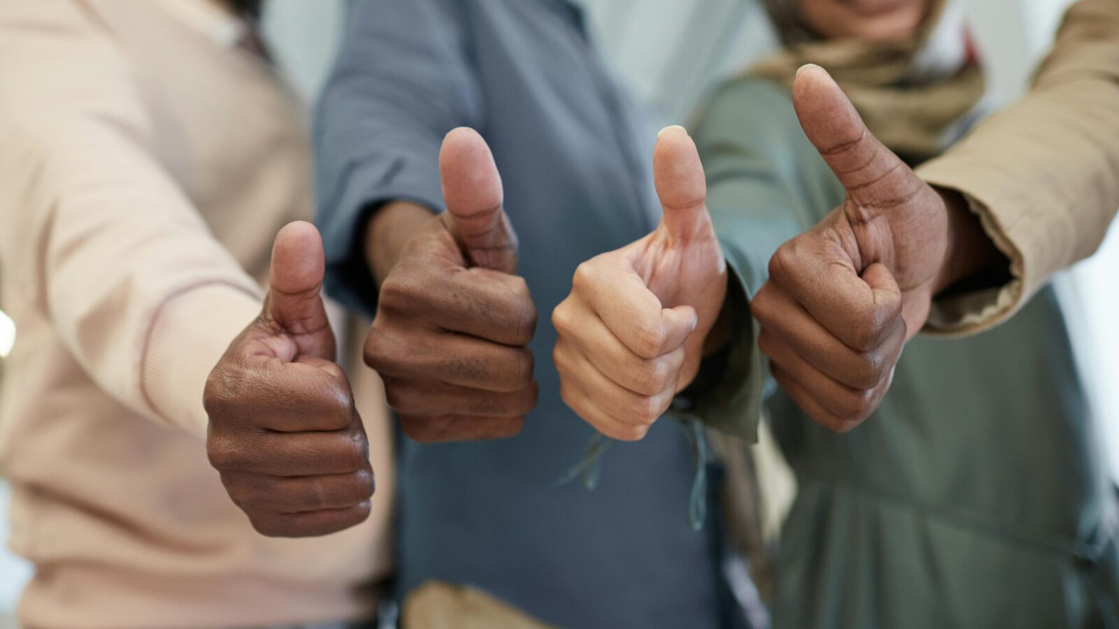 Several people giving a thumbs-up together